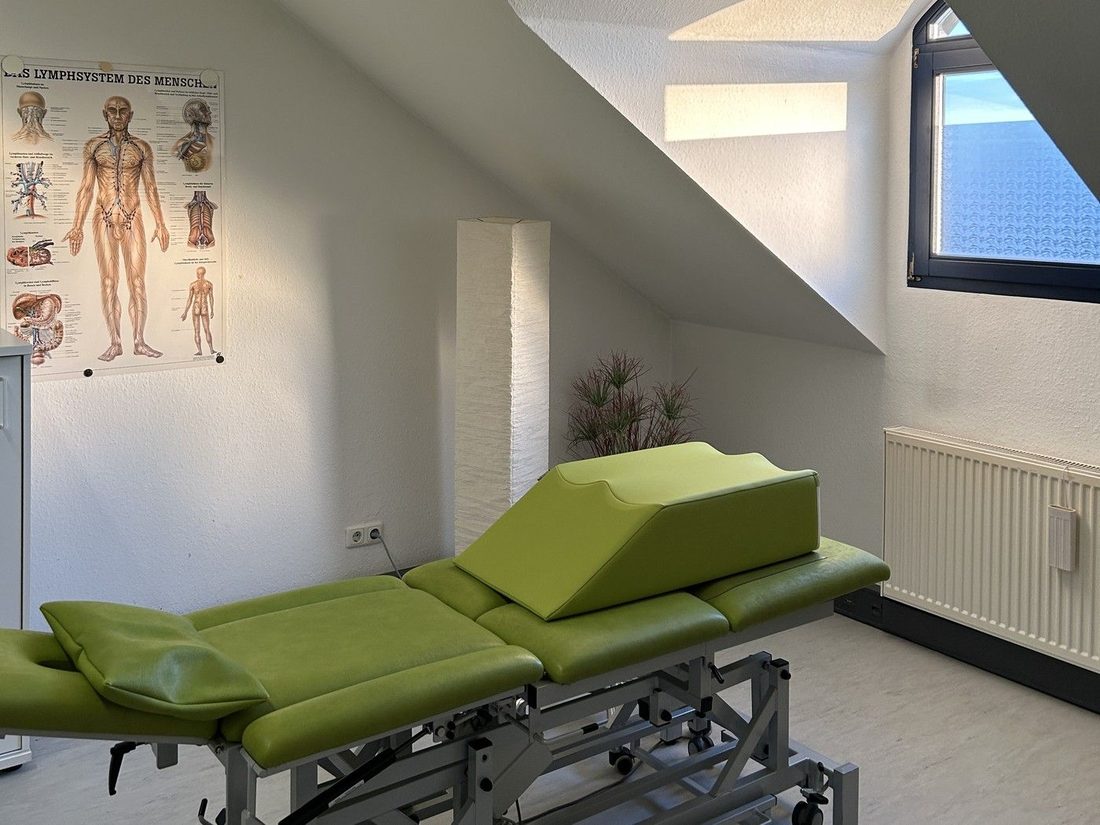Behandlungsraum unter der Dachschräge mit Therapieliege und Lagerungskeil